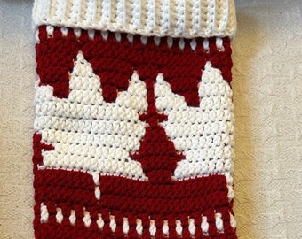 May include: A red and white crocheted Christmas stocking with a pattern of white Christmas trees on a red background.
