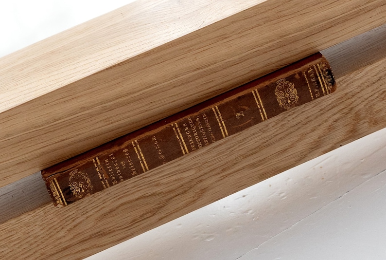 May include: A vintage book titled "Selections from the Writings of Henry D. Thoreau" is resting on a wooden shelf.
