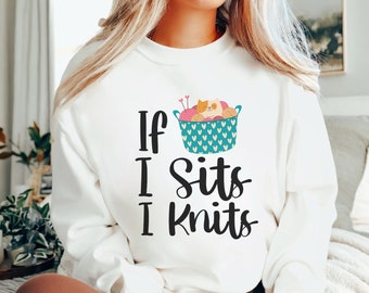 May include: White sweatshirt with the text "If I sits I knits" and a graphic of a teal basket filled with yarn and knitting needles.