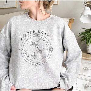 May include: Gray sweatshirt with a graphic of three origami cranes flying in a circle with stars and the text "F M M P R B O X Y S" around the circle.