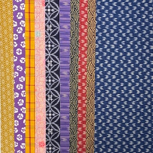 May include: A collection of ten fabric strips with various patterns and colors. The fabrics include geometric, floral, and abstract designs in shades of gold, purple, yellow, pink, red, black, and blue. The fabrics are arranged vertically.