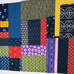Può includere: Un patchwork di vari campioni di tessuto in tonalità di blu, rosso, giallo, verde e viola. I tessuti presentano diversi motivi, tra cui disegni floreali, geometrici e astratti. La disposizione mostra una varietà di trame e colori.