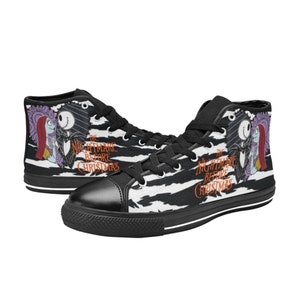 K&ouml;nnte beinhalten: Schwarz-wei&szlig;e High-Top-Canvas-Schuhe mit Zebra-Muster. Die Schuhe zeigen ein Grafikmotiv von Jack Skellington und Sally aus dem Film "Nightmare Before Christmas".