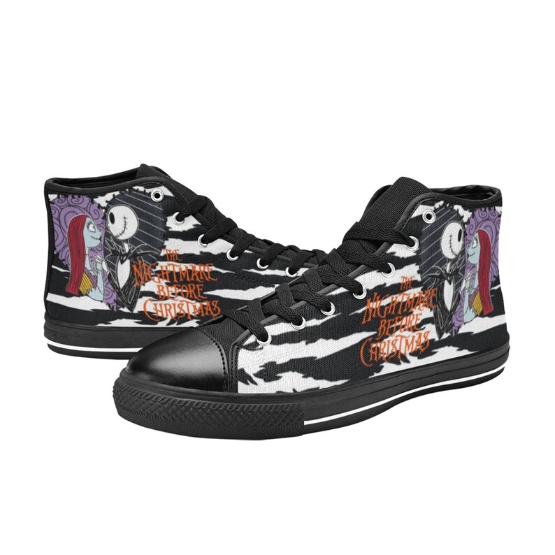 K&ouml;nnte beinhalten: Schwarz-wei&szlig;e High-Top-Canvas-Schuhe mit Zebra-Muster. Die Schuhe zeigen ein Grafikmotiv von Jack Skellington und Sally aus dem Film "Nightmare Before Christmas".