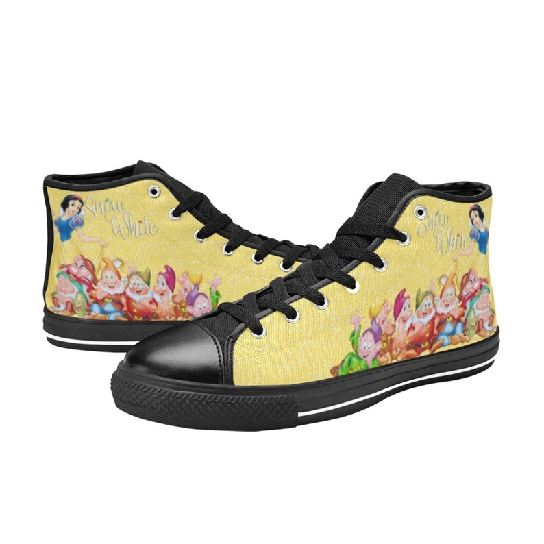 K&ouml;nnte beinhalten: Hohe Sneaker mit gelbem Hintergrund, die Schneewittchen und die sieben Zwerge zeigen. Die Schuhe haben schwarze Schn&uuml;rsenkel, eine schwarze Zehenkappe und eine wei&szlig;e Sohle. Die Worte "Snow White" sind auf der Seite geschrieben.