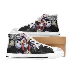 Op de afbeelding: Witte hoge canvas schoenen met een zwart-witte print van personages uit de film "The Nightmare Before Christmas". De schoenen hebben een witte zool en zwarte afwerking.