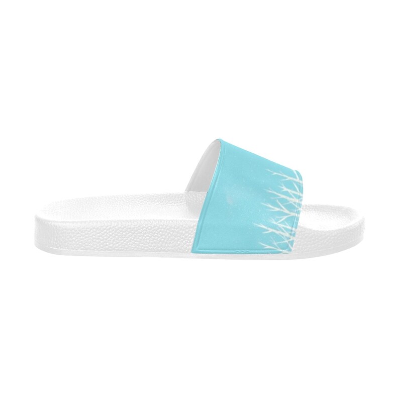 May include: White slide sandals with a light blue strap featuring a white abstract design.