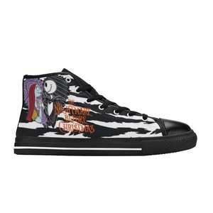 K&ouml;nnte beinhalten: Schwarz-wei&szlig;e High-Top-Canvas-Schuhe mit Zebra-Muster. Die Schuhe zeigen eine Grafik von Jack Skellington und Sally aus dem Film "Nightmare Before Christmas". Der Text "The Nightmare Before Christmas" ist an der Seite der Schuhe aufgedruckt.