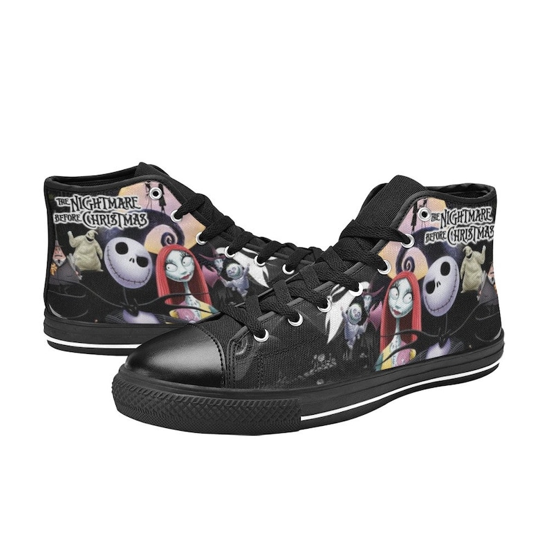 Op de afbeelding: Zwarte hoge canvas sneakers met een print van personages uit de film "The Nightmare Before Christmas". De print bevat Jack Skellington, Sally en andere personages. De schoenen hebben witte veters en een witte streep rond de zool.