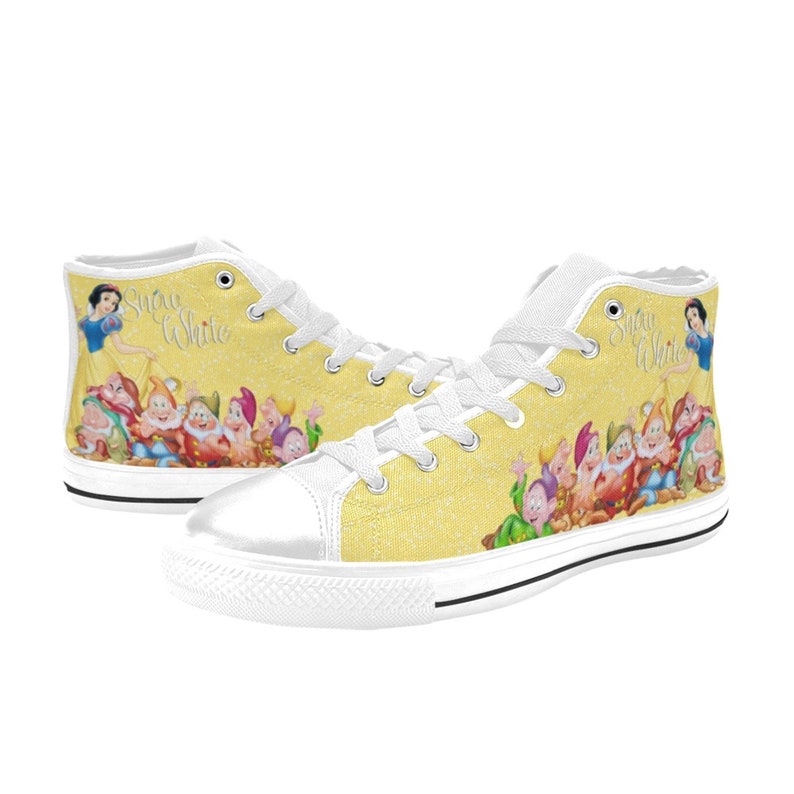 K&ouml;nnte beinhalten: Hohe Sneaker mit gelbem Hintergrund, die Schneewittchen und die sieben Zwerge zeigen. Die Schuhe haben wei&szlig;e Schn&uuml;rsenkel, eine wei&szlig;e Zehenkappe und den Schriftzug "Snow White".