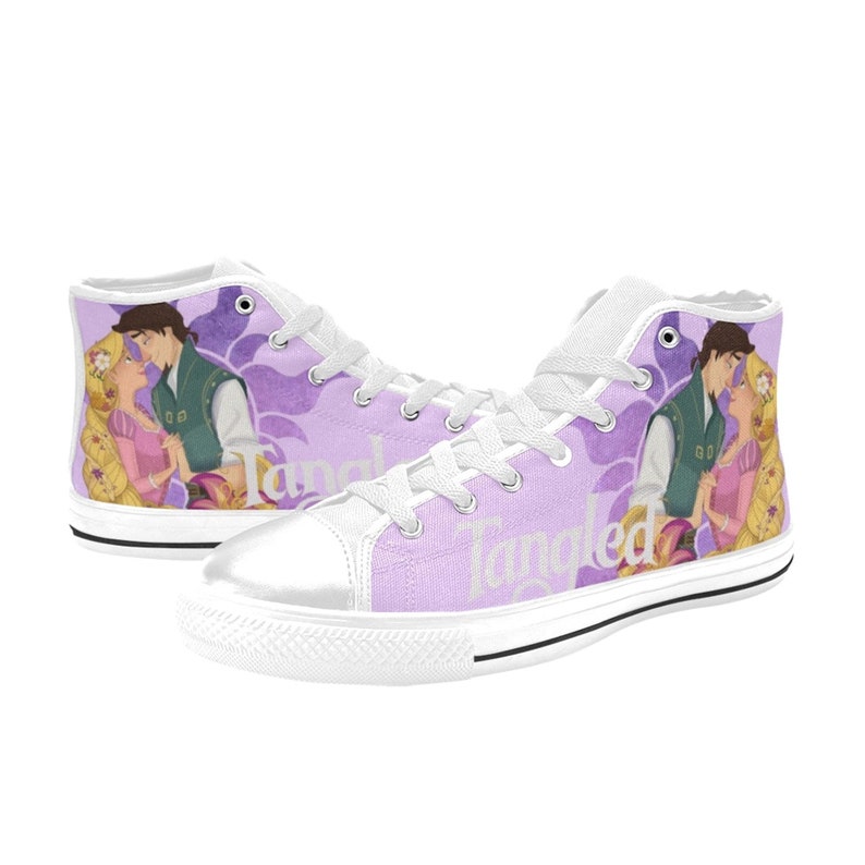 May include: White high-top canvas shoes with a purple and white floral design. The shoes feature a graphic of Rapunzel and Flynn Rider from the Disney movie Tangled. The word "Tangled" is written in white on the side of the shoes.