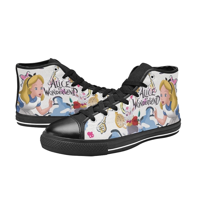 May include: Black high-top canvas sneakers with a white background featuring a colorful Alice in Wonderland design. The design includes Alice, the Cheshire Cat, a pocket watch, and keys. The text "Alice in Wonderland" is printed on the shoes.