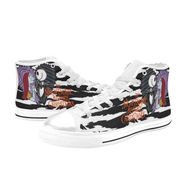 K&ouml;nnte beinhalten: Wei&szlig;e High-Top-Canvas-Schuhe mit einem schwarz-wei&szlig;en Zebra-Muster. Die Schuhe zeigen ein Motiv von Jack Skellington und Sally aus dem Film "Nightmare Before Christmas".