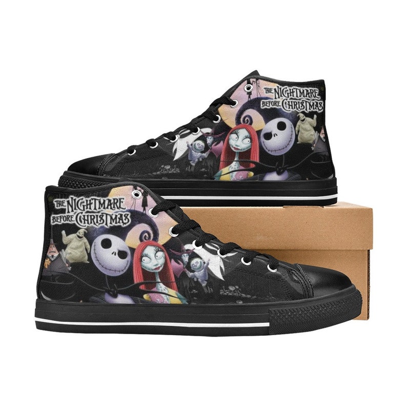 Op de afbeelding: Zwarte high-top canvas schoenen met een print van personages uit de film "The Nightmare Before Christmas". De schoenen hebben witte veters en een witte streep rond de zool.