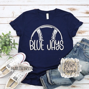 May include: A navy blue t-shirt with a white baseball graphic and the text "BLUE JAYS".