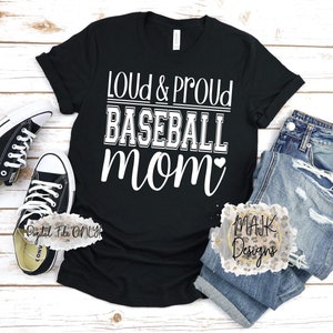 May include: Black t-shirt with white text that reads "Loud & Proud Baseball Mom" with a small heart after "Mom".