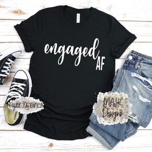 Puede incluir: Camiseta negra con texto blanco que dice "engaged af".