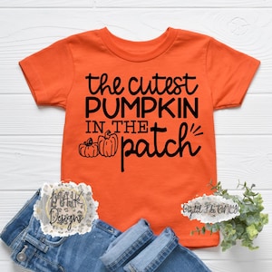 May include: Orange short-sleeved t-shirt with black text that reads "the cutest pumpkin in the patch" and a graphic of three pumpkins. The text "Digital File Only!" is in the bottom right corner.