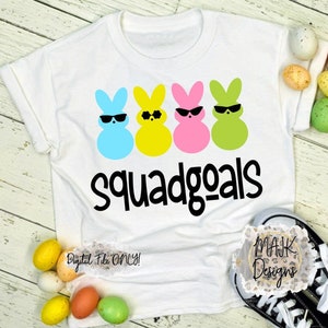 Puede incluir: Camiseta blanca con cuatro siluetas de conejos de Pascua de color pastel que llevan gafas de sol y el texto "squadgoals".