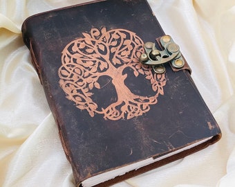 May include: A brown leather journal with a tree of life design and a brass clasp. The journal has a distressed look and is perfect for writing or sketching.