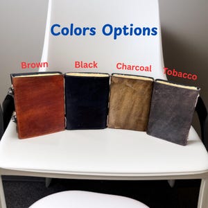 Puede incluir: Se muestran cuatro diarios de cuero en colores marr&oacute;n, negro, carb&oacute;n y tabaco. Los diarios son rectangulares con un borde de color claro y un cierre. El texto "Colors Options" est&aacute; encima de los diarios.