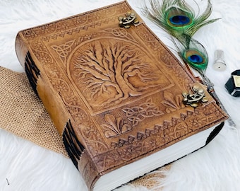 May include: A brown leather journal with a tooled design of a tree of life and Celtic knots. The journal has two brass clasps and is closed.