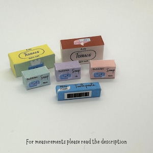 以下が含まれることがあります： ティッシュ、石鹸、歯磨き粉など、ミニチュアのバスルーム用品のセット。箱には、漫画の泡と「Bubbles Soap」と「Toothpaste」の文字が描かれています。