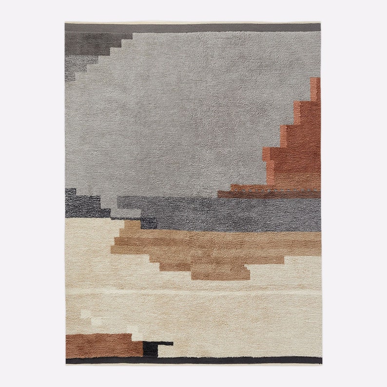 May include: A rectangular rug with a geometric design. The rug features a palette of grey, beige, brown, and rust. The design includes stepped shapes and horizontal bands, creating a textured, abstract landscape.