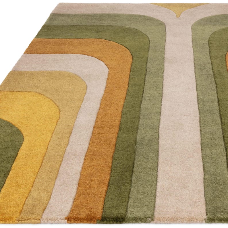May include: A colorful area rug with a retro design. The rug features curved stripes in shades of green, gold, tan, and cream. The rug's pattern creates a sense of movement and adds a vibrant touch to any room.
