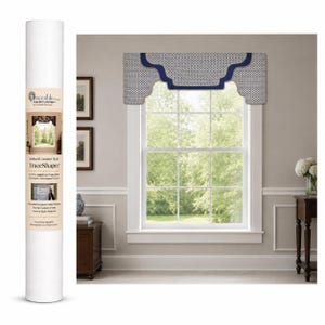 May include: A white cylindrical tube labeled Traceable Designer TraceShaper Arched Cornice Style DIY kit, next to a window featuring a custom-fitted valance with a small-scale black and white geometric pattern and a solid navy blue trim border.