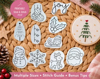 May include: A collection of white stick and stitch embroidery patterns featuring Christmas motifs including a snowman, reindeer, Santa Claus, snowflake, sleigh, holly, ornaments, and the text joy and ho ho ho, with a finished tree in a wooden hoop.