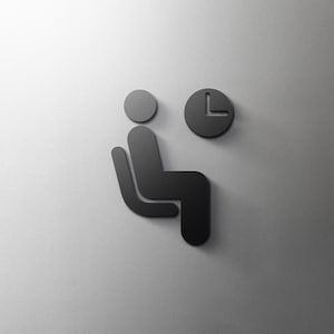 May include: Black and white icon of a person sitting on a chair with a clock above them. The icon is on a white background.