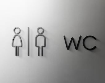 May include: A black and white sign with the text "WC" and gender symbols for men and women.