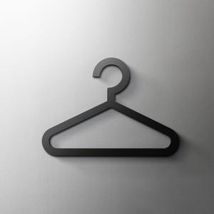 Puede incluir: Una percha de metal negro con un gancho en la parte superior. La percha tiene un diseño simple con una forma redondeada.