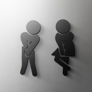 Puede incluir: Íconos de silueta en blanco y negro de una persona de pie y una persona sentada, que representan un letrero de baño.