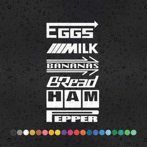 Puede incluir: Pegatinas de vinilo blanco con las palabras "EGGS", "MILK", "BANANAS", "BREAD", "HAM" y "PEPPER" sobre un fondo negro.