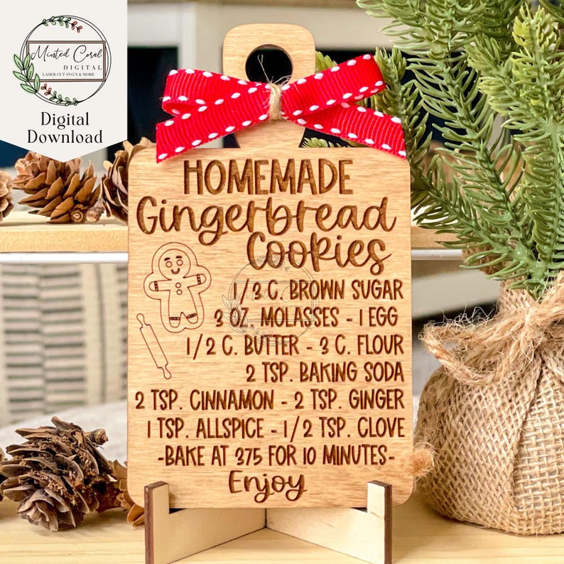 May include: A wooden gingerbread cookie recipe ornament with a red and white polka dot ribbon. The recipe is for homemade gingerbread cookies and includes ingredients like brown sugar, molasses, butter, flour, baking soda, cinnamon, ginger, allspice, and cloves. The ornament also includes instructions to bake at 375 degrees Fahrenheit for 10 minutes. The ornament says "Enjoy" at the bottom.