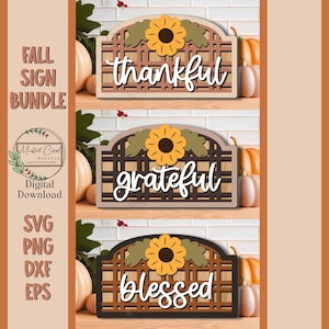 May include: A bundle of three wooden fall signs with the words "thankful", "grateful", and "blessed" in white script. Each sign features a sunflower and leaf design. The signs are digital downloads.