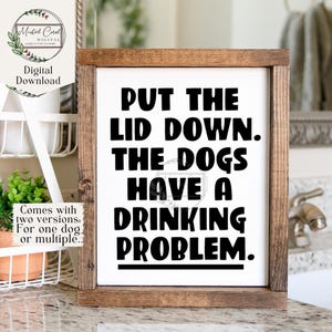 Peut inclure: Une pancarte blanche avec un cadre en bois brun, avec le texte "PUT THE LID DOWN. THE DOGS HAVE A DRINKING PROBLEM."