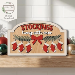 May include: Wooden Christmas sign with the words "STOCKINGS hung with care" in red and white. The sign features six red stockings with white cuffs, a red bow, and green sprigs. The sign is on a wooden background.