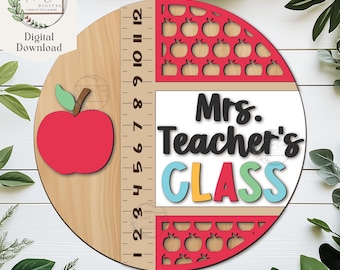 May include: A wooden circle with a ruler, a red apple, and the text "Mrs. Teacher's CLASS" in colorful letters. The circle is decorated with a pattern of red apples.