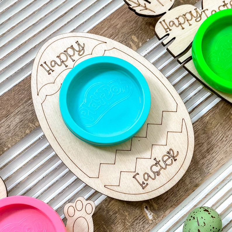 May include: Wooden Easter egg-shaped tray with the words "Happy Easter" and a blue Play-Doh container.