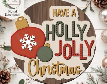 May include: A round wooden Christmas sign with the words "Have a Holly Jolly Christmas." The sign features a red ornament with a white snowflake, a green ornament, and gold accents. The background has a wood grain pattern.