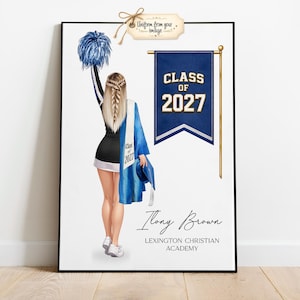 Op de afbeelding: Een ingelijste print met een blonde cheerleader in een zwart-wit uniform met een blauwe pompon, een blauwe afstudeerstola en een baret. Een blauwe banner toont CLASS OF 2027. Tekst bevat Tony Brown en LEXINGTON CHRISTIAN ACADEMY.