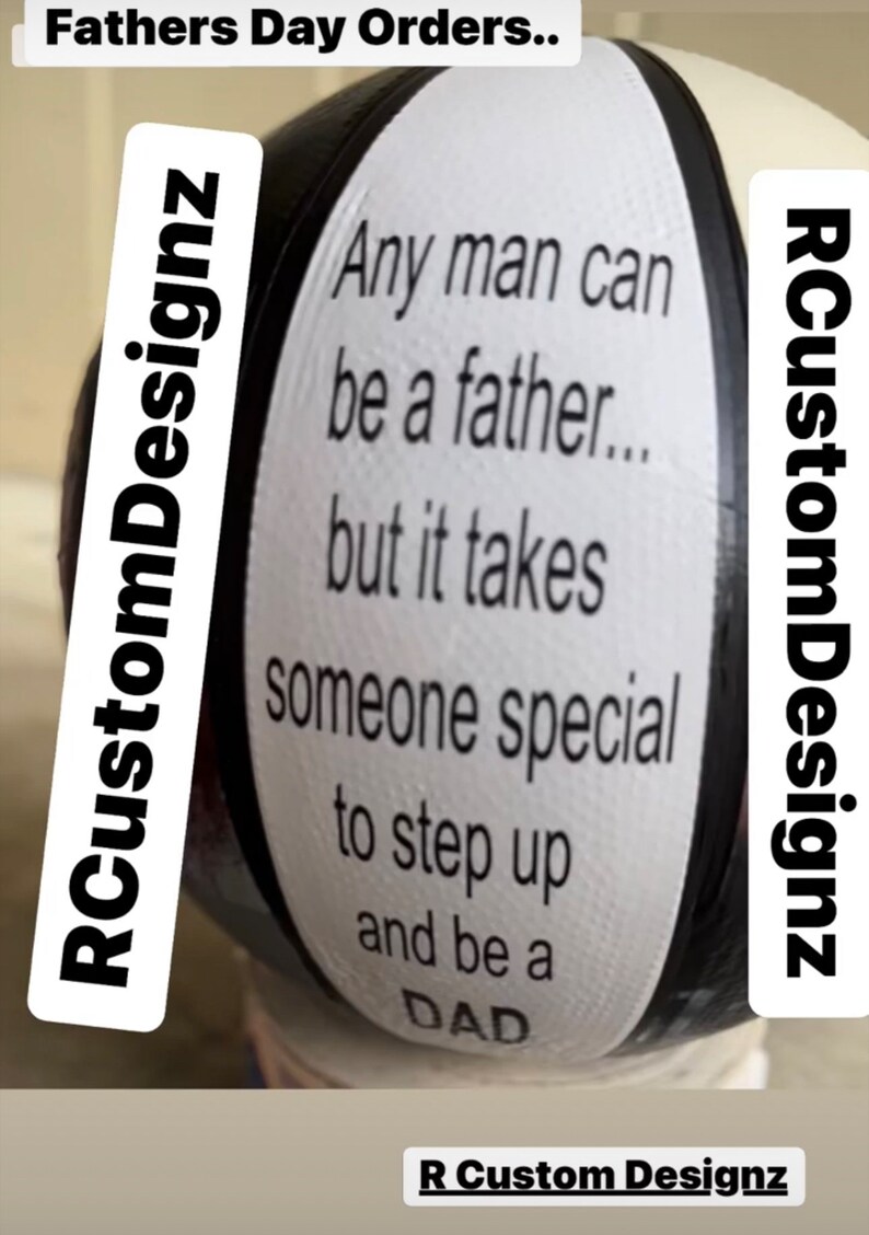 Op de afbeelding: Een zwart-witte afbeelding van een rond object met de tekst "Any man can be a father... but it takes someone special to step up and be a DAD" erop gedrukt. De tekst "RCustomDesignz" is links en rechts op het object gedrukt.