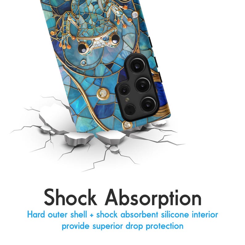 Peut inclure: Une coque de t&eacute;l&eacute;phone bleue et dor&eacute;e avec un motif en mosa&iuml;que repr&eacute;sentant une grenouille. La coque a un renflement de cam&eacute;ra sur&eacute;lev&eacute; avec un objectif de cam&eacute;ra noir.