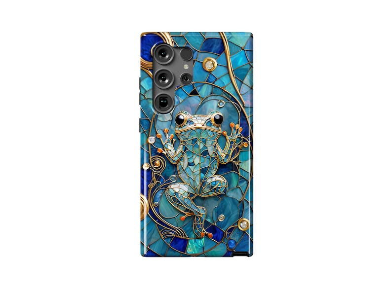 Peut inclure: Une coque de t&eacute;l&eacute;phone bleue et dor&eacute;e avec un motif en mosa&iuml;que repr&eacute;sentant une grenouille. La coque a une d&eacute;coupe pour l'objectif de l'appareil photo.