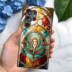 May include: A phone case with a stained glass design featuring a woman in a circle surrounded by gold and blue accents. The case has a camera cutout with three lenses.