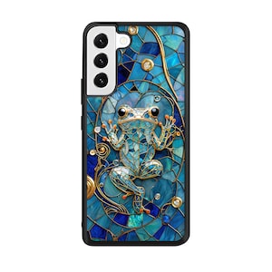 Peut inclure: Une coque de t&eacute;l&eacute;phone bleue et dor&eacute;e avec un motif en mosa&iuml;que repr&eacute;sentant une grenouille. La coque a une d&eacute;coupe pour l'objectif de l'appareil photo.