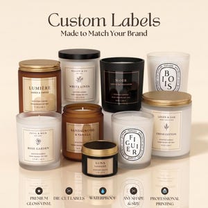 May include: A collection of various scented candles in glass and metal containers with custom labels. The labels feature brand names like Lumière, White Linen, Noir, Bois, Rose Garden, Sandalwood & Vanilla, Luna, Figuier, and Linen & Oak.